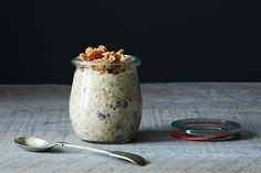 a glass jar filled with oatmeal sitting on top of a table next to a spoon