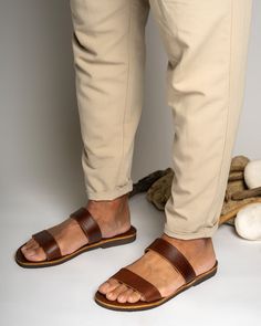 Men's handmade leather sandals in brown color are a stylish and functional choice for any occasion. Made from high-quality leather, these sandals are durable and comfortable to wear. The intricate detailing and design work add a touch of elegance to the overall look of the sandals.  All of our products are handmade with the best and highest quality leather from our beloved island of ''Crete''.  The leather used for each item may be irregular in terms of colour and texture due to its natural char Casual Brown Toe Ring Sandals With Leather Sole, Brown Slides With Rubber Sole And Single Toe Strap, Brown Slides With Rubber Sole, Brown Slides With Single Toe Strap And Rubber Sole, Brown Leather Footbed Toe Ring Sandals, Brown Leather Sole Slide Sandals, Brown Toe Loop Sandals With Leather Lining, Brown Slide Sandals With Leather Sole, Brown Slides With Leather Lining And Single Toe Strap