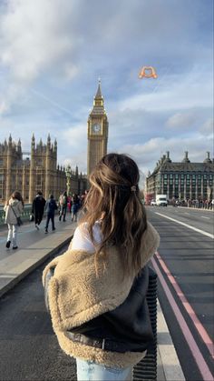 a woman standing in front of big ben and the houses of parliament