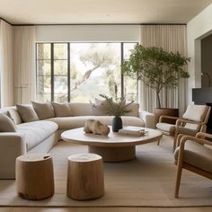 a living room filled with furniture and large windows