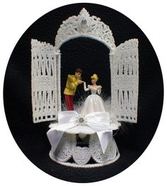 a wedding cake topper with a bride and groom standing on it's side