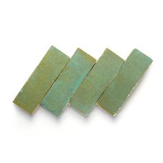 four pieces of green tile sitting on top of each other