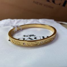 Nwt! Beautiful Authentic Coach Hinge Bangle Bracelet In Yellow Gold, With Delicate Rhinestones And “C” Logos. Very Elegant. An Accessory That Goes Well With Any Outfit. Brand New, Tags Attached. Opens Up For Easy On And Off. Comes With Coach Branded Retail Store Gift Box And Coach Branded/Logo Tissue Paper. Ready To Gift! - Hinge Closure - Insert Buckle Design Designer Plaque - Adjustable Push-Stud Fastening - 2.25” Diameter And 2” Width Approximately This Listing Includes: - New Coach Bracelet With Tags - White Jewelry Pouch/Coach Drawstring Bag - Coach Gift Box - Coach Branded Tissue Paper, Logos New To Poshmark? Sign Up Now With My Code Mmrt330 To Save $10 On Your Fir Coach Bracelets Bangles, Elegant Coach Jewelry In Yellow Gold, Luxury Adjustable Bracelet By Coach, Coach Bracelets As Gift, Elegant Coach Yellow Gold Jewelry, Coach Adjustable Bangle, Luxury Adjustable Coach Bracelets, Adjustable Coach Bangle, Luxury Adjustable Coach Bracelet