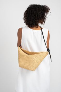 Medium shoulder and crossbody bag with an adjustable vegetable-tanned leather strap handwoven in natural straw. Features two large folds at top for closure. Pennisetum purpureum natural fiber and Vegetable-tanned leather Handmade in Ghana and France. Natural Leather Bag With Woven Detail, Eco-friendly Woven Leather Shoulder Bag For Vacation, Eco-friendly Natural Woven Leather Shoulder Bag, Luxury Eco-friendly Woven Leather Shoulder Bag, Eco-friendly Woven Straw Shoulder Bag, Pantry Decor, Garden Clogs, Handwoven Bag, Knit Outerwear