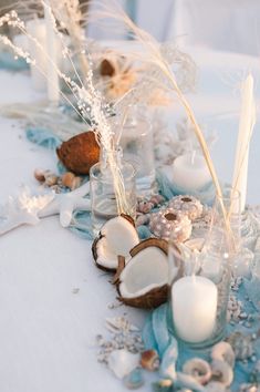 the table is decorated with shells, candles and seashells