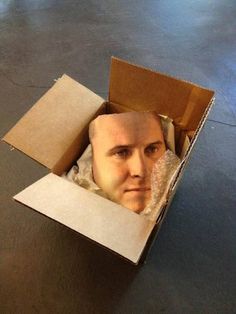 a cardboard box with a man's head in it