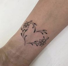 a person with a tattoo on their arm that has flowers in the shape of a heart