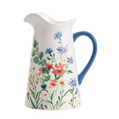 a white and blue pitcher with flowers painted on it