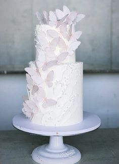 a white wedding cake with butterflies on top