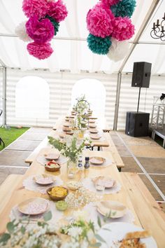 a long table set up with plates and flowers on it for a party or event