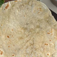 an uncooked tortilla sitting on top of a cutting board