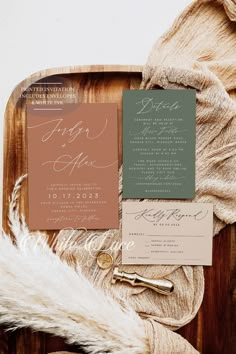 the wedding stationery is laid out on a wooden tray with fur and other items