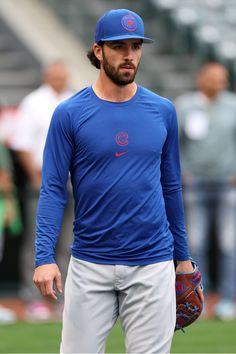 a baseball player wearing a blue shirt and holding a catchers mitt