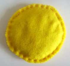 a yellow felt circle sitting on top of a white table