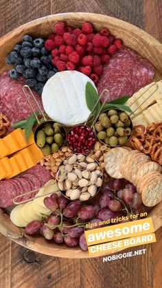 a wooden bowl filled with different types of cheeses and crackers on top of it