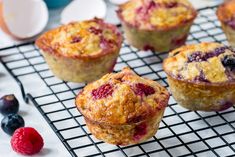 several muffins on a cooling rack with berries