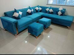 a blue sectional couch with matching footstools and ottomans in a living room