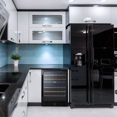 a black and white kitchen with an oven, refrigerator, sink and countertop area