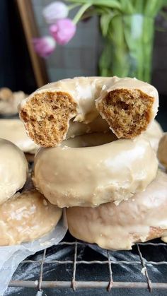 there are donuts that have been frosted with icing on the cooling rack