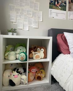 the stuffed animals are on display in the small shelving unit next to the bed