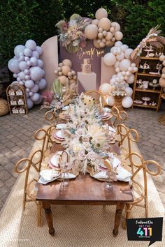 a table is set up with balloons and flowers