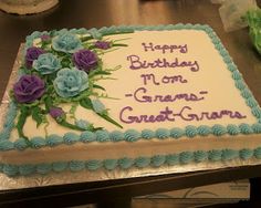 a birthday cake with blue and purple flowers on it