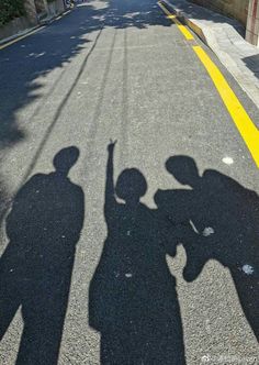 the shadow of two people holding hands in the street