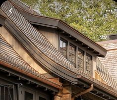 the roof of a house with wooden shingles and metal guttering on it