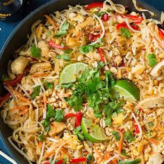 a wok filled with rice and vegetables on top of a blue table next to chopsticks