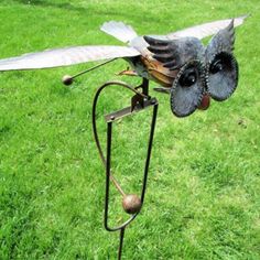 a metal bird sculpture sitting on top of a green field