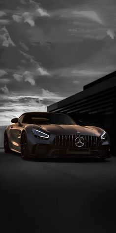 a mercedes sports car parked in front of a building at night with dramatic clouds overhead