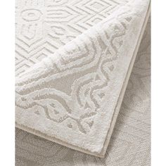 a white rug with an intricate design on the top and bottom part of it's surface