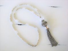 "Four different styles of silver beaded tassel necklaces to choose from, designed and handmade by Ralston Originals. I made all the tassels with silver chains, and covered each in a beautiful antique silver metal bead cap. The first beaded necklace (Pictures 1-3), is made with a very unique and beautiful large silver bead, with many tiny crystal inlaid accents. The necklace is also made with a large antique silver crystal roundel, and a large clear crystal bead. The beaded chain on the necklace Adjustable Beaded Chain Tassel Necklace As Gift, Adjustable Tassel Necklace With Dangling Beads As Gift, Adjustable Tassel Necklace With Dangling Beads For Gift, Lariat Beaded Necklace With Tassels For Gift, Gift Lariat Beaded Necklace With Tassels, Handmade Silver Long Tassel Necklace, Adjustable White Tassel Necklace Gift, White Long Tassel Necklace As Gift, Tassel Necklace With Round Beads For Gifts