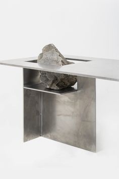 a metal table with a rock in the center