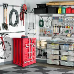 an organized garage with lots of tools and storage bins on the wall next to a bicycle