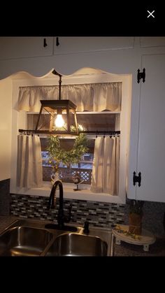 a kitchen sink under a window next to a faucet