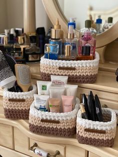 three baskets filled with personal care items on top of a dresser next to a mirror