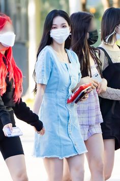 three girls wearing masks and holding hands