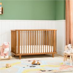 a baby crib in the corner of a room with stuffed animals on the floor