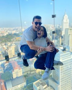 a man and woman are jumping in the air with their arms around each other while smiling