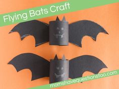 two bats made out of toilet paper on an orange background