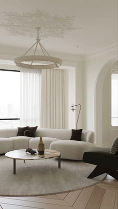 a living room filled with furniture and a round table in front of a large window