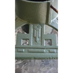 a close up of a green vase on a lace table cloth with a pipe sticking out of it