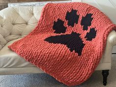 an orange and black afghan on a white chair