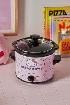 a hello kitty crock pot sitting on top of a kitchen counter next to a pink pig