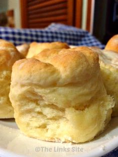 some biscuits are on a white plate with blue checkered cloth