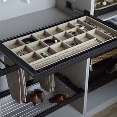 an open drawer with several pairs of shoes and other items in it on the shelf