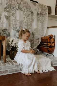 This Katherine Embroidered Linen Dress is designed with exquisite attention to detail. Made from lightweight white linen and adorned with delicate lace, this dress is perfect for outdoor play in the summer, yet also gorgeous for any special occasion. Soft and comfortable, it is sure to keep your girl looking and feeling her best. Charming white linen and embroidered lace dress with a large tie bow in the back. Composition: 70% Cotton, 30% Linen. Machine wash. Iron for the best look. This style i First Communion Spring Dress With Lace Trim, White Floral Embroidered Dress For Baptism, Bohemian Lace Dress With Broderie Anglaise, Embroidered Summer Baptism Dress, Embroidered Summer Dresses For Baptism, Lace Dress For First Communion In Summer, White Lace Dress For Baptism In Spring, White Lace Dress For Spring Baptism, White Linen Ruffled Dress For Beach