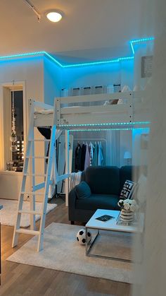 a loft bed is lit up with blue lights in the living room and bedroom area