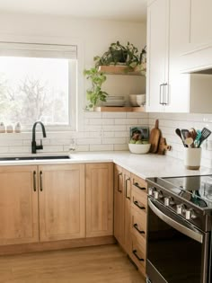 a kitchen with wooden cabinets and stainless steel stove top oven, dishwasher and window